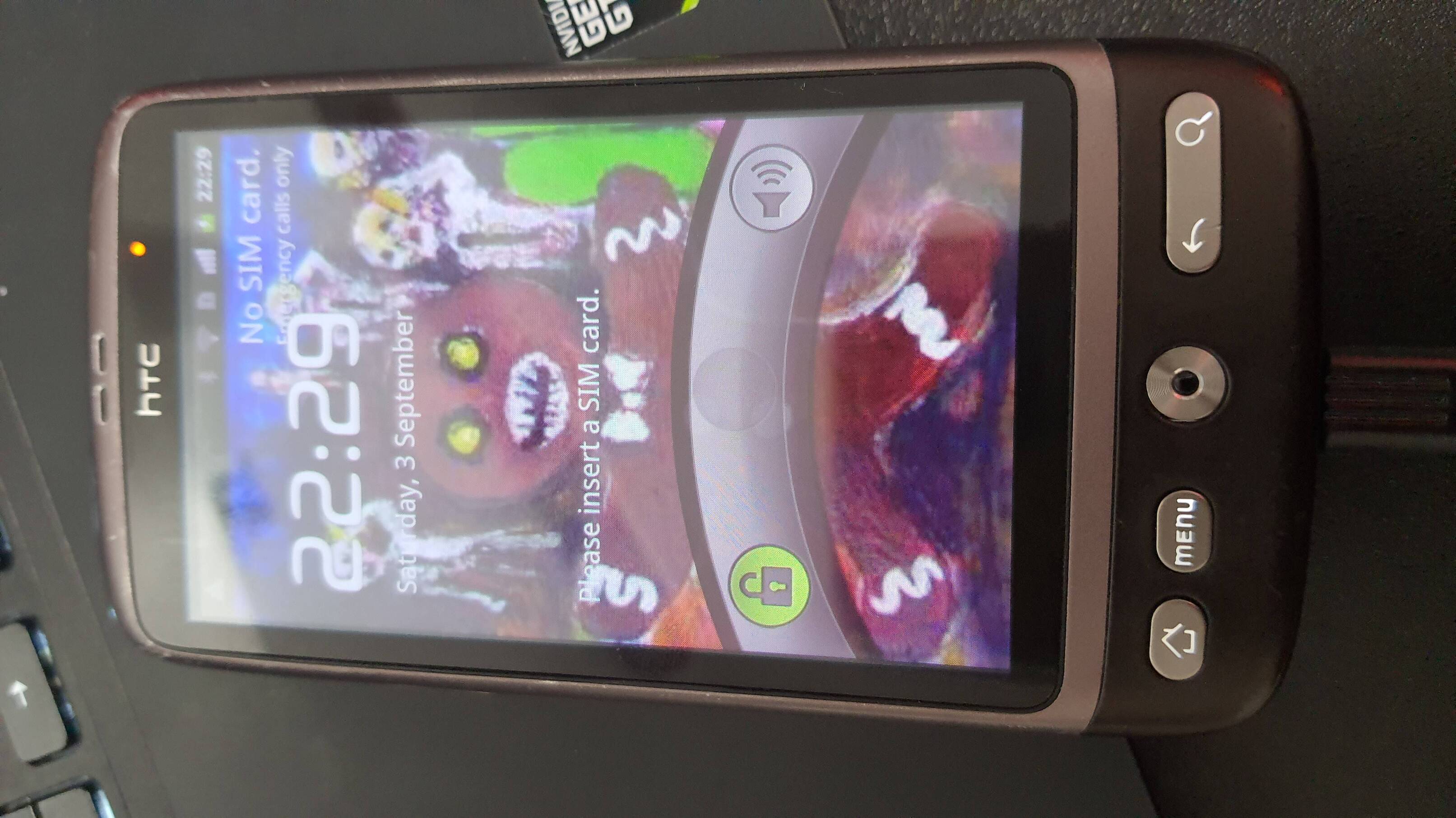 a very small old HTC smartphone. It has menu, home and back buttons, as well as a trackball.